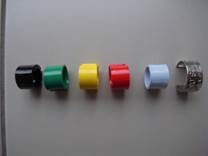 zes ringen in de kleuren zwart, donkergroen, geel, rood, lichtblauw en een metalen ring